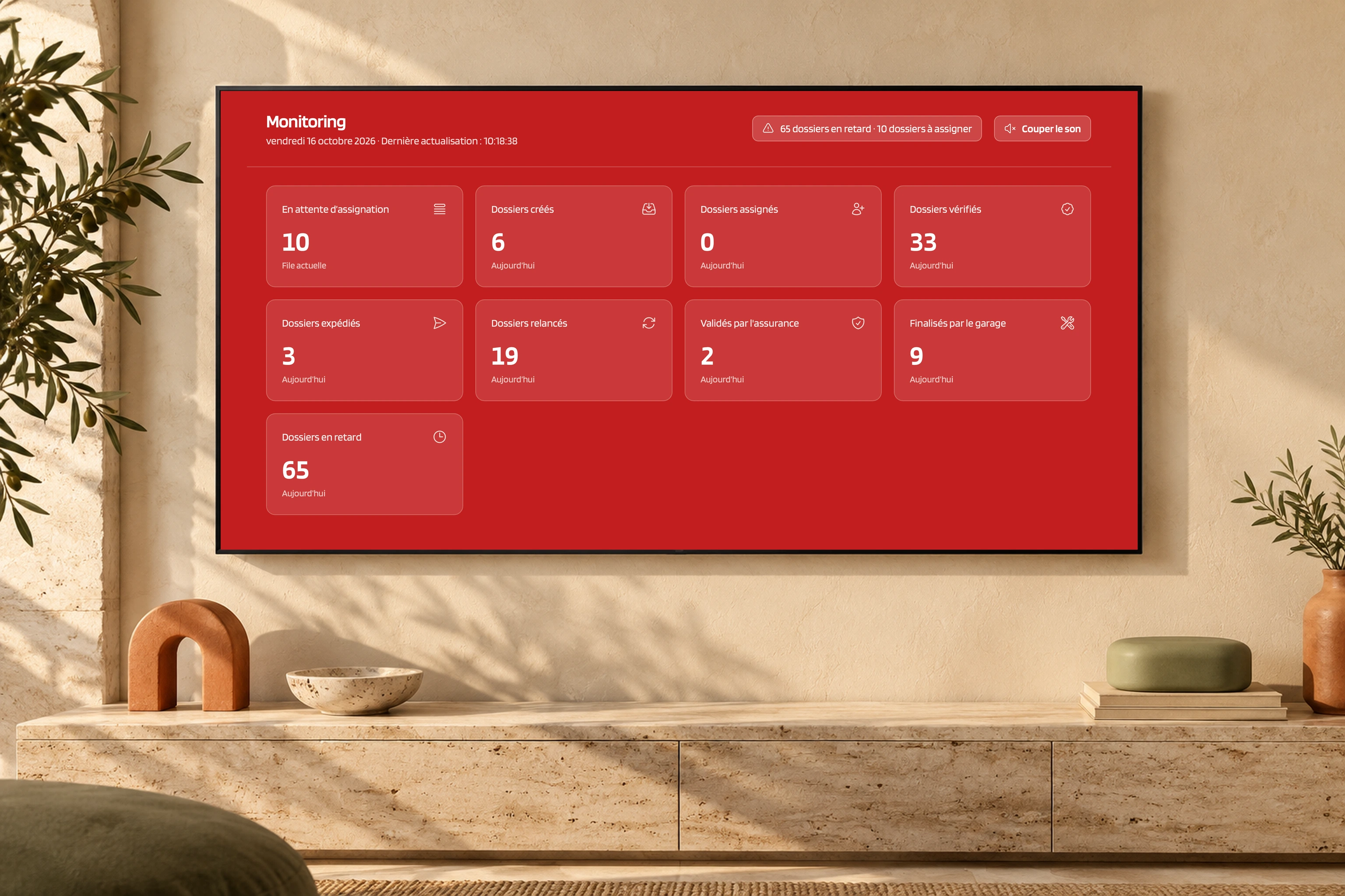 Tableau de monitoring Pare-Brise Éco intégré géométriquement dans une télévision murale, dans un décor de travertin, sauge et terracotta.